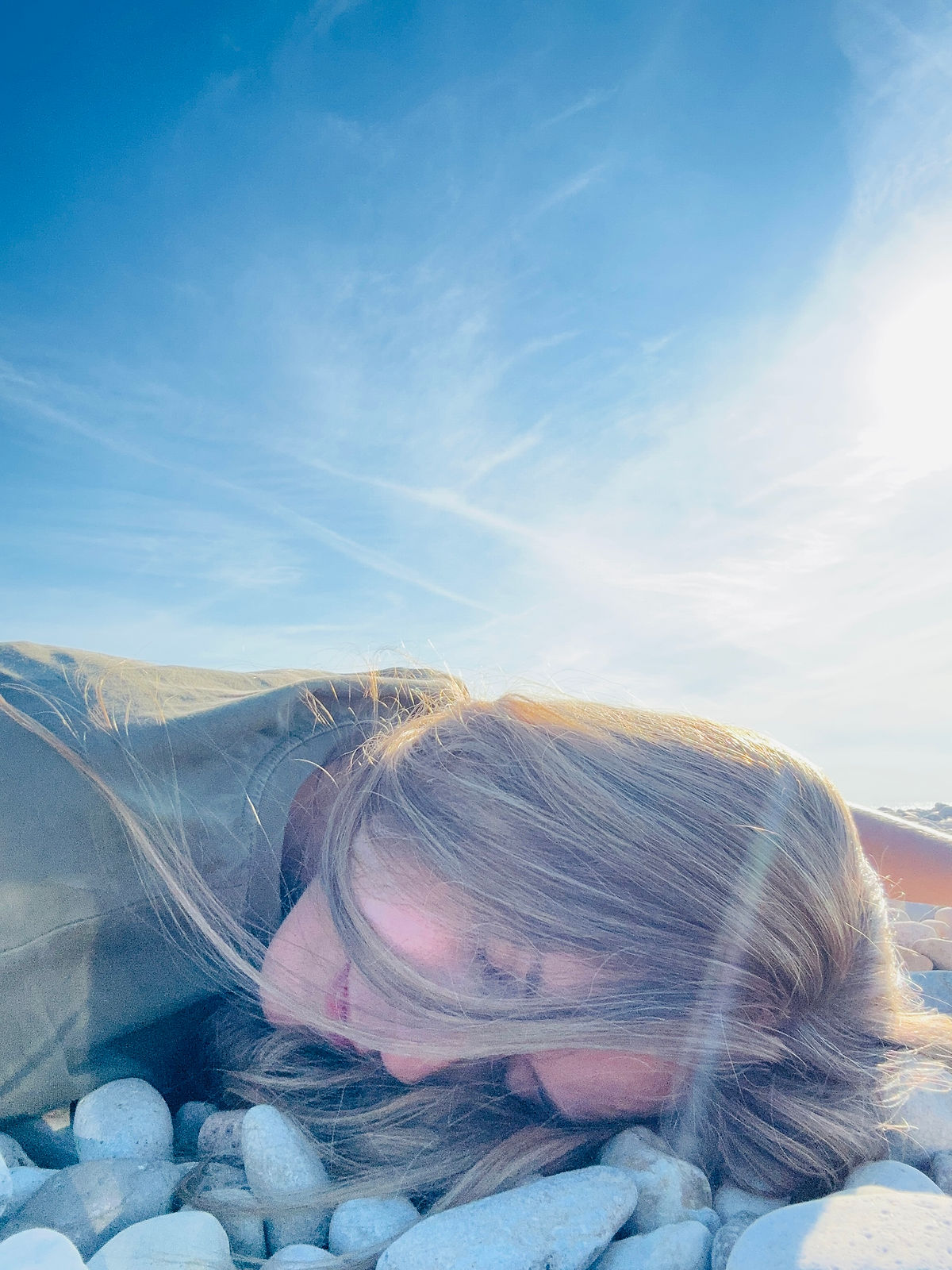 girl on the beach lying on rocks