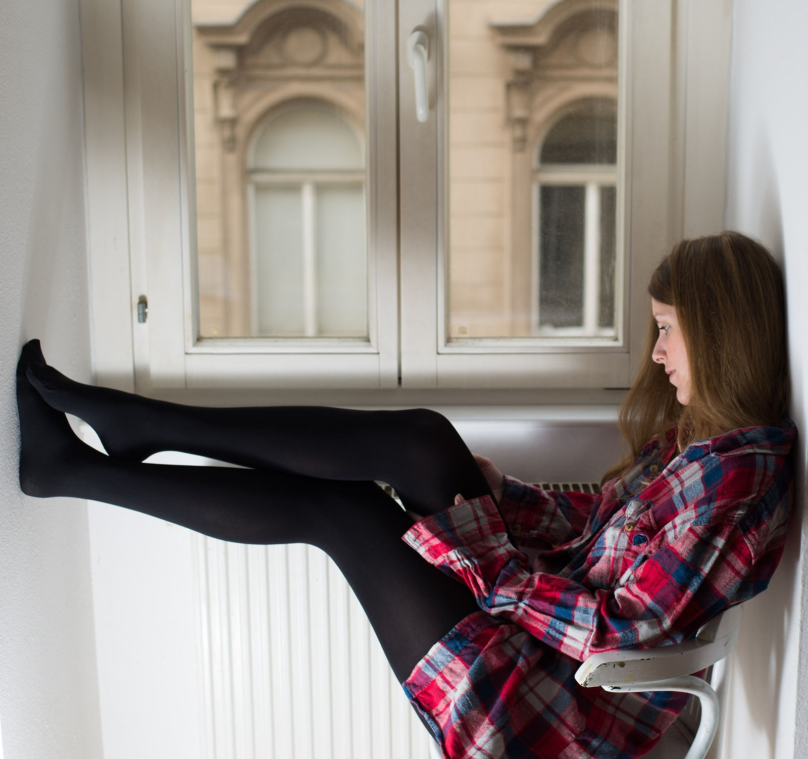 Woman sitting next to a window